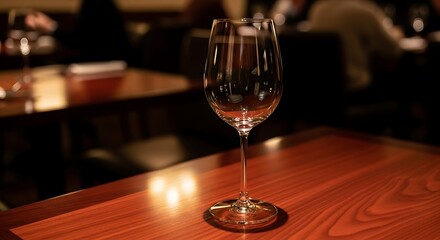 Empty clear wine glass on a polished wooden table in a dimly lit restaurant setting empty glass clear glass