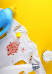 Vertical photo format.A Stained Baby Shirt, Resting with Detergent on a Bright Background Surface