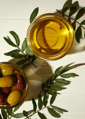 Vertical photo format. A premium olive oil with olives and fresh leaves, top view 