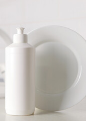 Vertical photo format.Dishwashing detergent and lemons on a light background