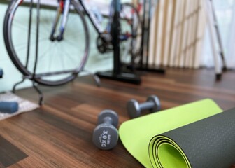 Dumbbells and exercise equipments on floor for workout at home blur background