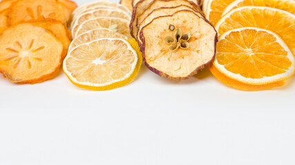 Dried fruits on a white background. Orange, lemon, persimmon, apple.