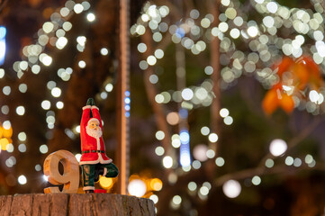 ヨガポーズのサンタ人形とイルミネーションのボケが広がるクリスマス風景