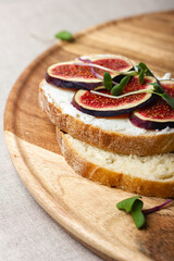 Slices of white bread with young cream cheese, freshly sliced figs and radish sprouts.
