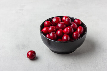 Fresh cranberries in black ceramic bowl