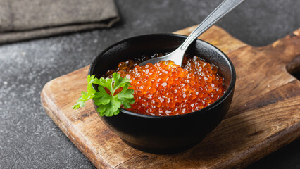 Bowl full of red salmon caviar with parsley