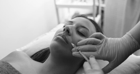 Young woman doing botox treatment inside private medical clinic - Beauty trends and anti aging concept - Black and white editing - Powered by Adobe