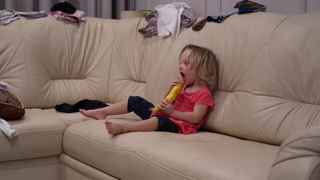 Child on messy sofa experiences emotional arc: crying with banana, happily eating it, then tearful tantrum, neglecting fruit.