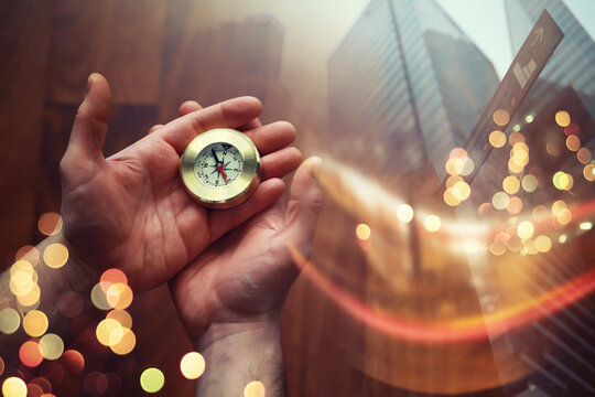 Double exposure businessman with vintage compass in a hand and skyscraper. concept to make decision or choose direction - Powered by Adobe