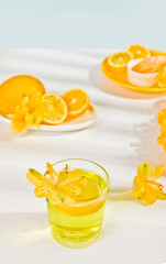A refreshing citrus cocktail in a glass garnished with an lemon slice and yellow flowers