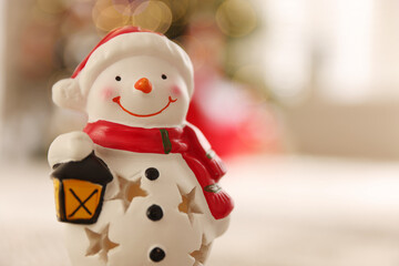 Cute snowman figure against blurred background, closeup with space for text. Merry Christmas and Happy New Year