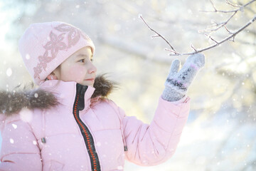 Winter walk on the street on a sunny frosty day. Family with children play snowballs in the park....