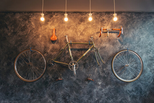 Vintage Bicycle on the wall decorate with bike cycle wheel in living room.Interior Design with people lifestyle hobby in a modern city. Bicycle with bulb lighting as background and loft decorate style - Powered by Adobe