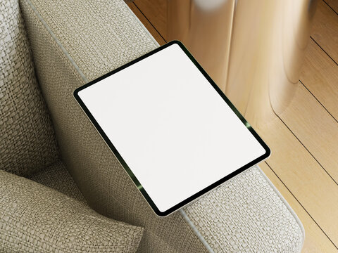 Tablet mockup on a cozy sofa with a light blanket and stylish fabric in a contemporary living room.