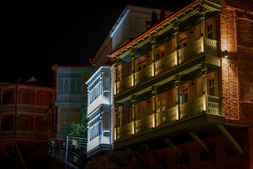 Traditional wooden balconies of Tbilisi houses dramatically lit at night