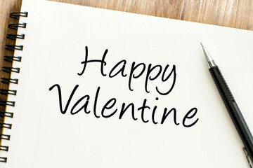 A heartfelt Happy Valentine message written in script on a white spiral notebook, perfect for expressing love and affection on this romantic holiday