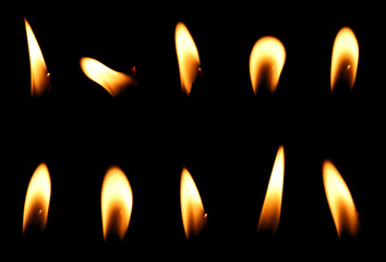 set candle flame is burning at night in close range, yellow light isolated on a black background....