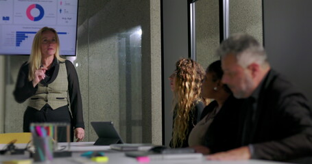 Female boss scolds employee for checking phone during presentation in tense office meeting, asserting authority and addressing disrespectful behavior in corporate setting