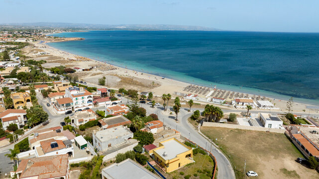 Aerial view of Marzamemi beach, a tourist resort in southern Sicily, in the province of Syracuse, Italy. The coast overlooks the Mediterranean Sea, whose waters are turquoise and crystalline. - Powered by Adobe