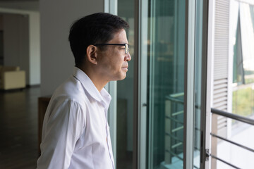 Side portrait of a Asian man with vitiligo, an uneven skin color condition, indoor scene.