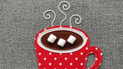 Cozy red polka dot mug filled with hot chocolate topped with marshmallows and swirling steam