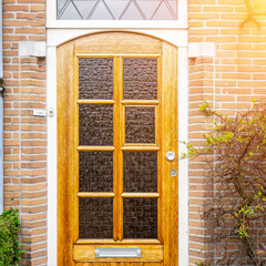 Facade of typical Dutch door house with brick walls, steps, front door windows. Doors on the street, Netherlands