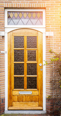 Facade of typical Dutch door house with brick walls, steps, front door windows. Doors on the street, Netherlands