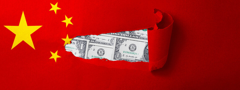 World map with the country of China. Ripped paper reveals an American dollar bill. Economic relationship and interdependence between China and the United States