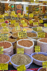 A vibrant display of various nuts and dried goods at a bustling Turkish market, with price tags and labels in Turkish.