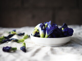 blue butterfly pea flower and kaffir lime fruit on fabric background aroma oil and shampoo home made