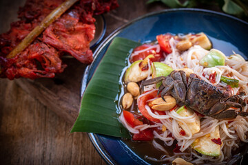A vibrant Thai Som Tum with rice noodles presented in a rustic still life setting. Fresh vegetables, bold spices, and authentic textures ideal for food concepts, menus, culture, and culinary visuals.