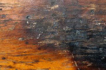 Brown wooden background with the scratch and black burning part