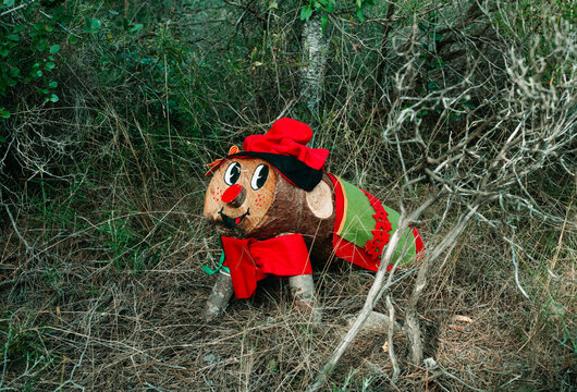 a colorful Tio de Nadal among forest branches