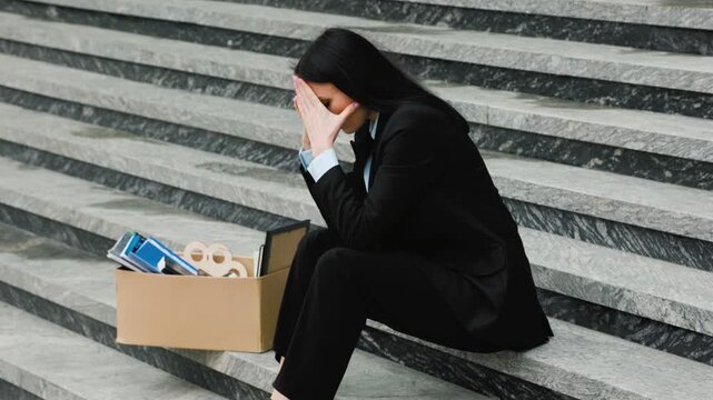Fired and Feeling Hopeless A Woman Sitting on Stairs with a Workless Sign