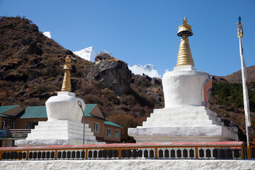 Stupas with golden spires against a clear blue sky in a serene mountainous landscape