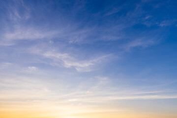 Thin cloud texture background and orange light sky,a photorealistic wide texture of a sky at sunrise, soft orange fading into light blue above, with only a few thin clouds visible. No ground elements.
