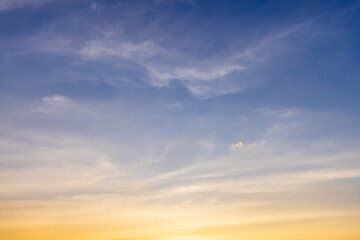 Thin cloud texture background and orange light sky,a photorealistic wide texture of a sky at sunrise, soft orange fading into light blue above, with only a few thin clouds visible. No ground elements.