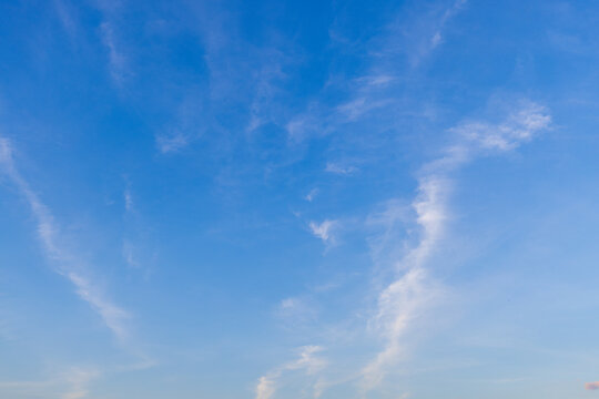 Thin cloud texture background and orange light sky,a photorealistic wide texture of a sky at sunrise, soft orange fading into light blue above, with only a few thin clouds visible. No ground elements.
