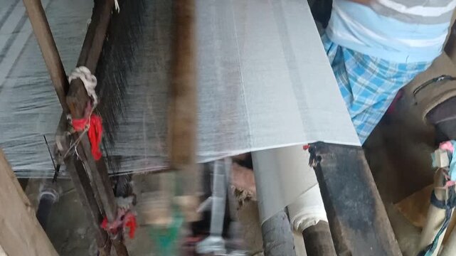 Handloom weaver working in loom	