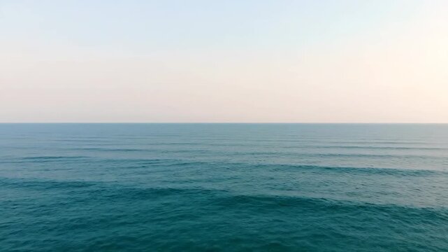 Expansive Ocean Surface Under a Soft Hazy Sky With Gentle Rain Falling Creating Ripples on the Deep Teal Water Horizon Line Visible With Subtle Gradient Lighting
