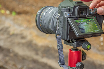長野県南牧村の渓流で三脚にセットしたカメラを操作する風景撮影
