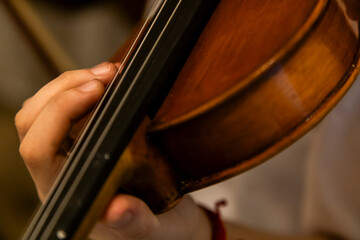 Close-up of a person holding and playing a violin.