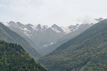 Obraz premium mountains valley forest peaks fog snow nature landscape, alpine scenery with green slopes and misty summit views for outdoor serenity