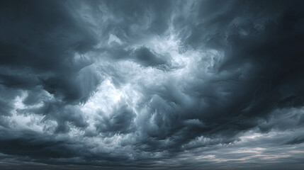Obraz premium A dramatic shot of a dark, ominous sky filled with swirling storm clouds. The scene evokes a sense of both awe and apprehension, with the turbulent atmosphere dominating the view