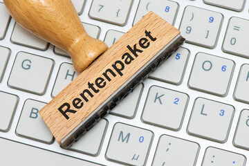 Ein Holzstempel ist beschriftet mit dem Aufdruck Rentenpaket als Symbolbild für Reformen im...