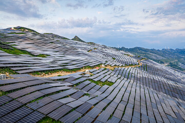 Solar power plant and wind turbines on mountain range.