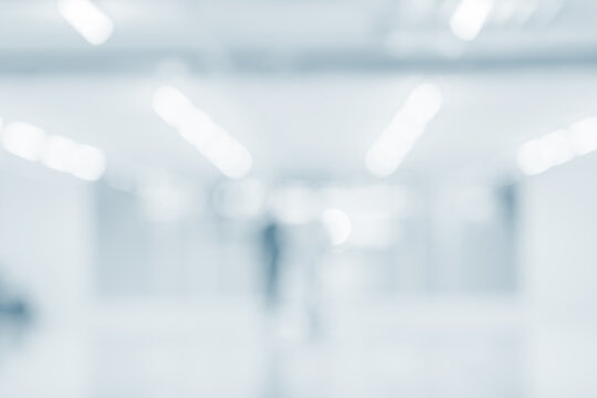 Blurred hospital hallway with bright clean lighting and soft blue tone background