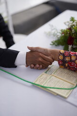 Formal Handshake Over a Marriage Registration Book During an Indonesian Wedding Ceremony