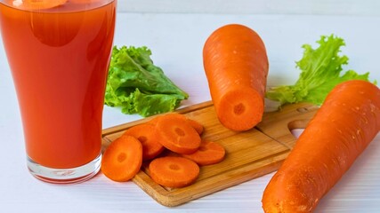 Freshly squeezed carrot juice with whole and sliced carrots