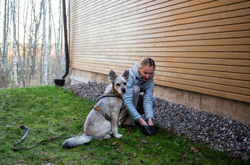 woman cleaning up after dog outdoors in residential yard